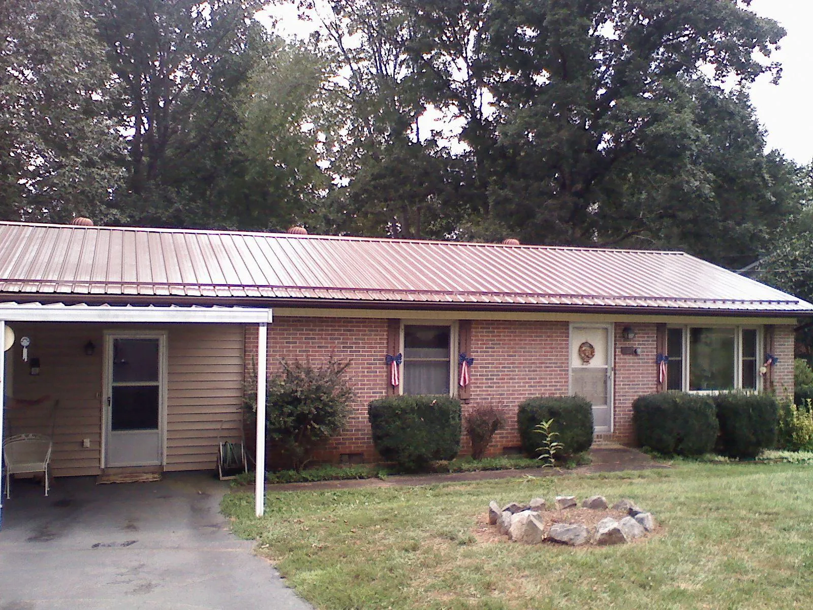 Bronze metal roof and carport on a brick ranch home — Roof Repair work by our crew in Balsam Grove